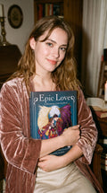 Woman holding a book titled 'Epic Love' in a cozy indoor setting